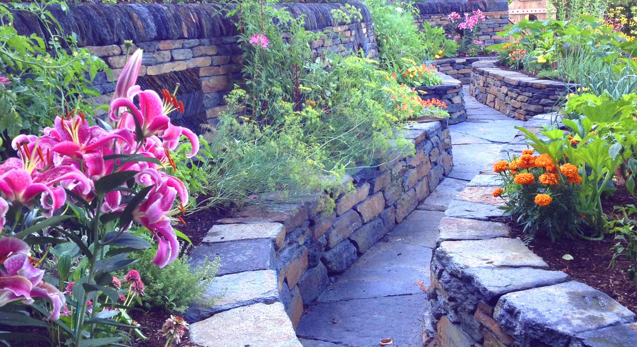 Raised stone garden beds, stone slab walkways and patios,